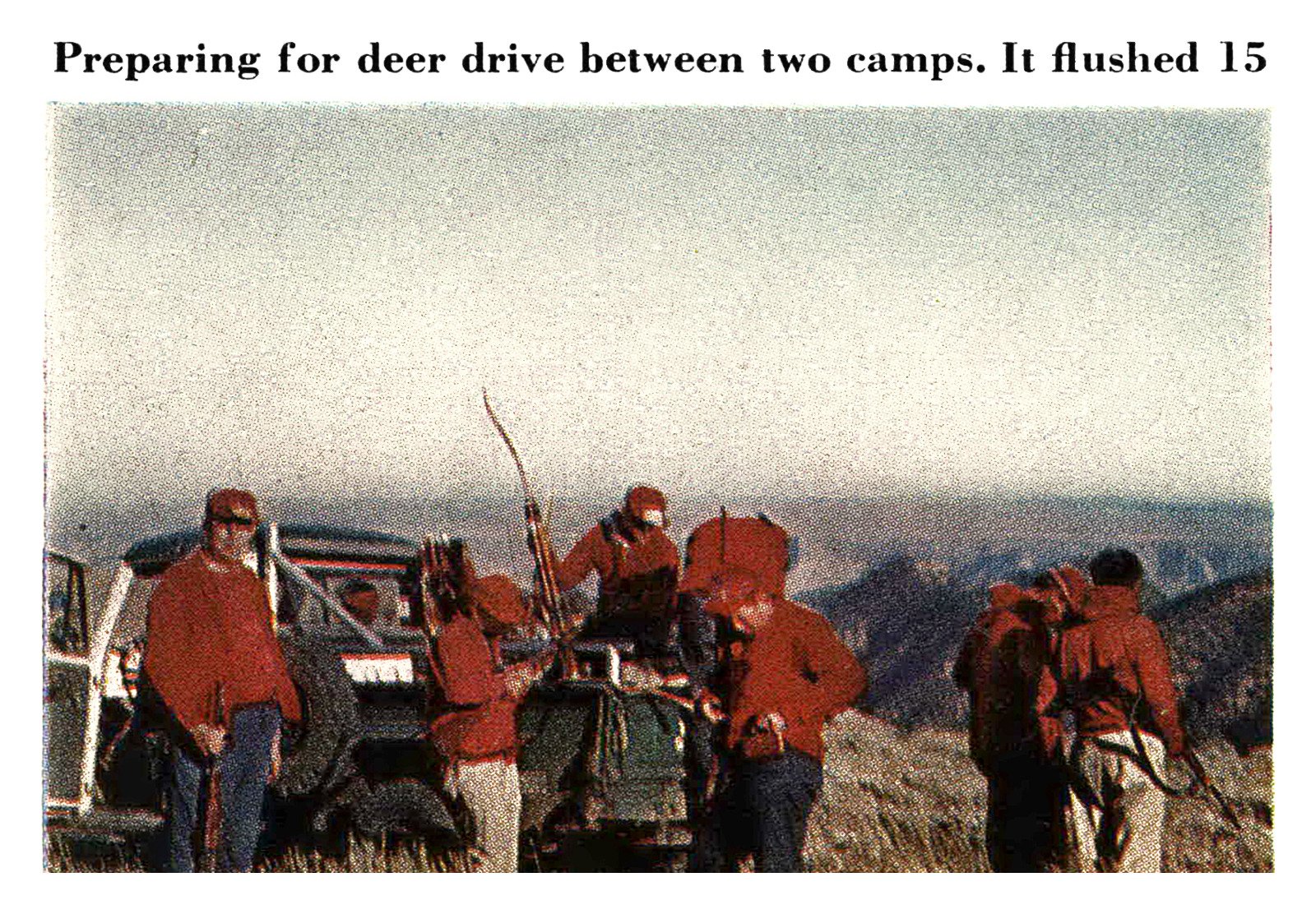 A group of hunters in red jackets, one holding a bow, gathers around a jeep on a high plateau before a deer drive.