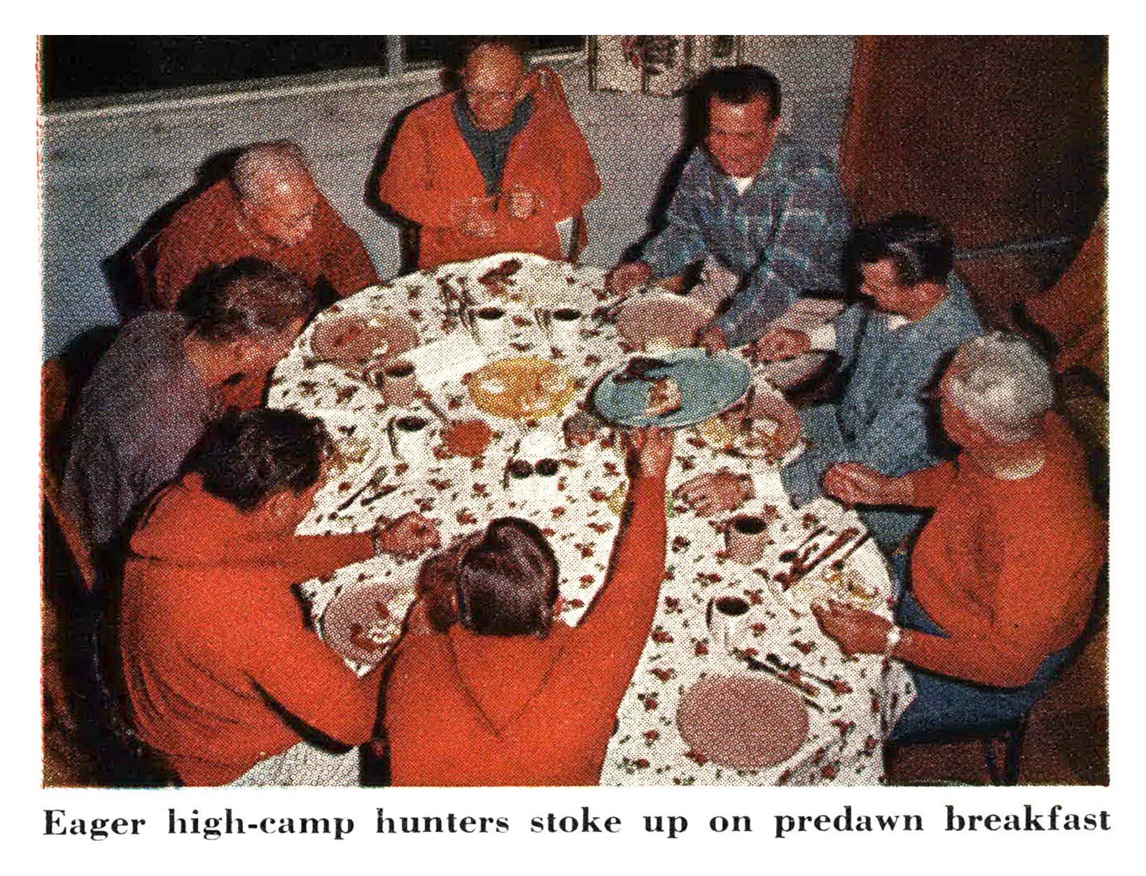 Hunters in red shirts and jackets eat breakfast around a table with a floral tablecloth in a cabin.