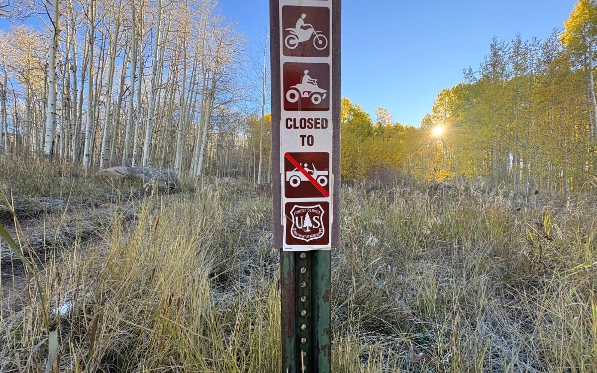 A USFS trail sign at the top of a mountain