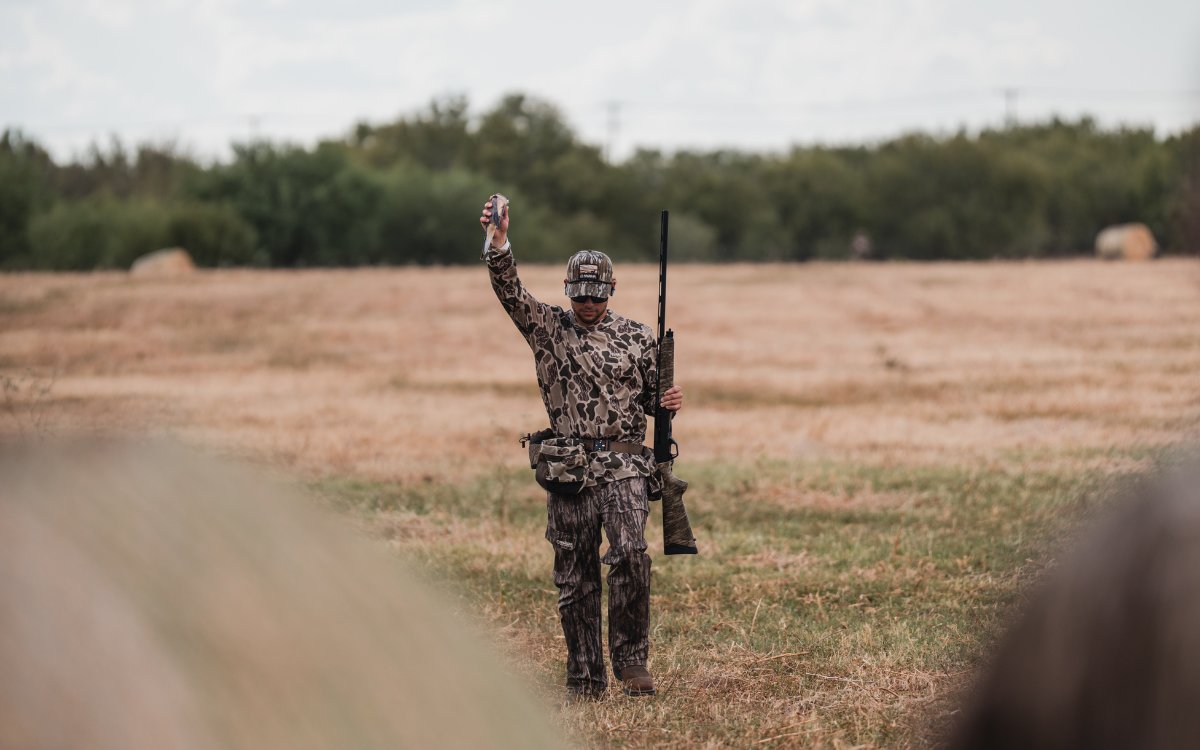 A hunter holding up a harvested dove.